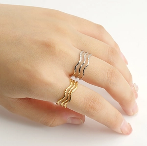 Stackable wave-shaped stainless steel rings with hammered texture in gold and silver finish