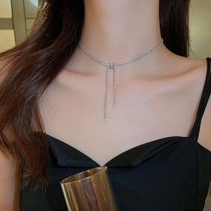 Macro shot of silver knot necklace with sparkling rhinestones worn on a female model