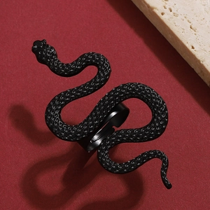 Detail of adjustable black snake ring with scale texture on a red textured background