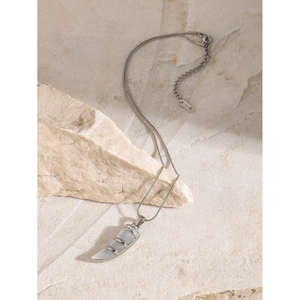 Macro detail of silver horn pendant with cat eye stones and rhinestones on snake chain