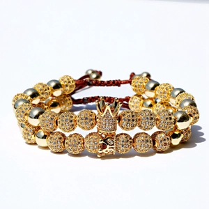 Luxurious gold beaded bracelet set with sparkling crown pendant on adjustable cord