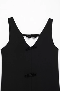 Détail de la robe dos nu en velours noir avec trois nœuds et une coupe en V profonde