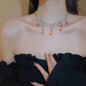 Detailed view of silver necklace with champagne pink teardrop crystals on model