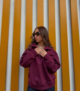 Gros plan d'un sweat-shirt polo bordeaux à manches longues avec poignets et col côtelés
