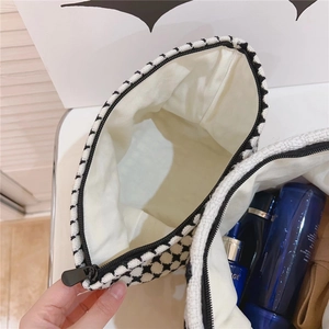 Vue détaillée de la trousse de maquillage en pied-de-poule avec espace pour produits de beauté