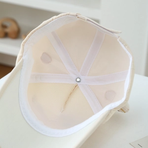 Detailed interior of kids' beige baseball cap showing reinforced seams and sweatband