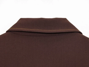 Detailed macro view of dark brown twill fabric with contrast yellow stitching on collar