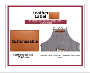 Detailed view of brown leather logo patch on a thick grey canvas apron with metal buckle