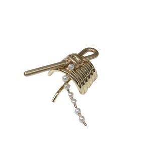 Elegant gold metal ear cuff with twisted design and pearl chain tassel for women