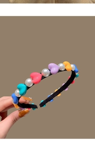Detail of handmade headband with colorful resin hearts and lustrous white pearls