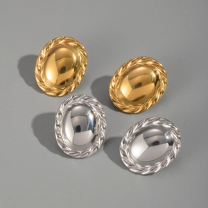 Close-up of gold and silver oval stud earrings with textured rope edges and mirror finish