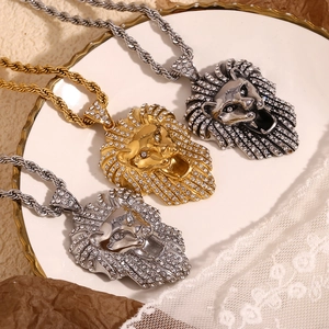 Trois pendentifs tête de lion en or et argent avec strass sur chaîne torsadée