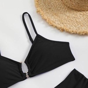 Detail of black bikini set with gold metal ring connector and summer straw hat