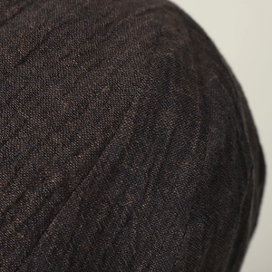 Close-up of deep brown linen texture and woven stitch details on the retro newsboy cap