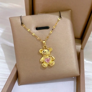 Golden teddy bear necklace with pink heart gem in a premium gift display box