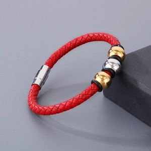 Detail of red braided leather bracelet with metallic beads and magnetic clasp