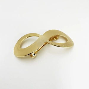 Macro detail of golden metal infinity hair clip with textured surface and punk style