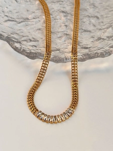 Detailed close-up of golden Cuban chain featuring 11 rectangular-cut zircon gemstones