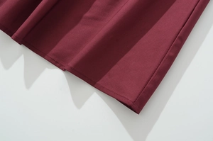 Detailed close-up of burgundy pleated fabric texture on a French style holiday dress