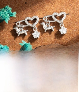 Detail of silver cartilage stud featuring hollow heart, dachshund, and star pendants
