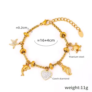 Detail view of 18k gold plated titanium steel bracelet with starfish and dolphin charms