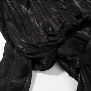 Détail du tissu en satin noir avec des textures plissées élégantes et des nœuds