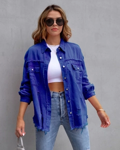 Detail einer dunkelblauen Jeansjacke im Distressed-Look mit Fransen und Vintage-Waschung