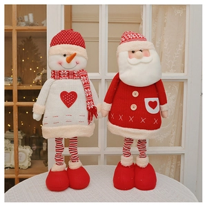 Detail of knitted plush Santa and Snowman figures with telescopic legs on lace tablecloth
