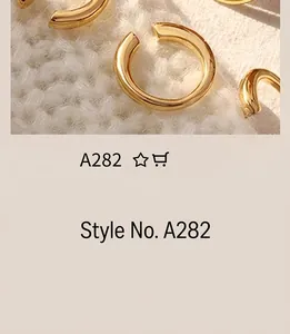 Macro shot of minimalist 18K gold plated C-shaped rings on white knit fabric texture