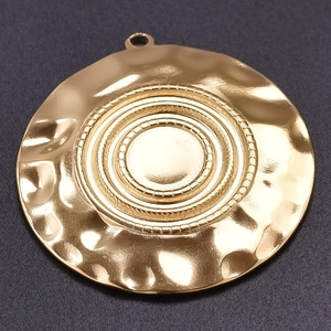 Macro shot of 304 stainless steel golden round pendant with hammered concentric texture