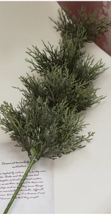 Macro detail of lifelike PE pine branches for Christmas tree decor on a beige background