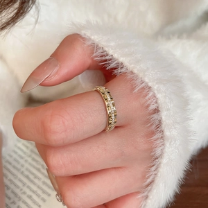 Détail d'une bague fleur plaquée or avec zircons étincelants portée au doigt d'un mannequin