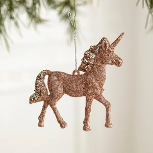 Sparkling rose gold glitter unicorn ornament hanging on a Christmas tree branch