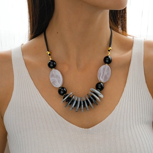 Detail shot of a bohemian double-layer necklace with black leather cord and acrylic beads