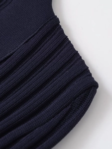Detailed macro view of dark blue ribbed knit fabric texture and high-quality stitching