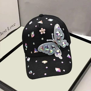 Detail of colorful rhinestones and crystal butterfly on black cotton baseball cap