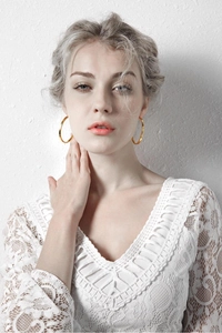 Elegant gold titanium steel hoop earrings on model wearing white lace dress