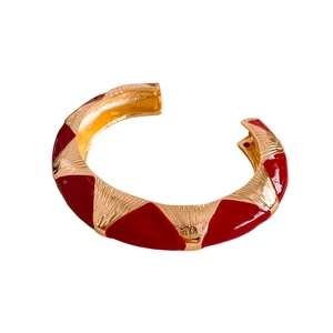 Vintage red and gold enamel open bangle featuring a geometric embossed pattern on white background