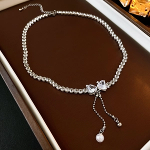 Detailed macro of a zircon heart necklace with elegant pearl tassels in a jewelry box