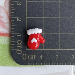 Size display of a mini red resin heart glove charm with ruler measuring 1.5cm by 2cm