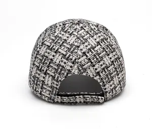 Detailed rear view of a black and white tweed baseball cap with adjustable strap