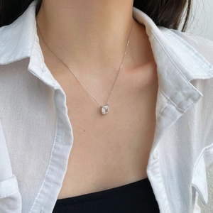 Macro detail of S925 silver necklace featuring a square cut zircon pendant on a model