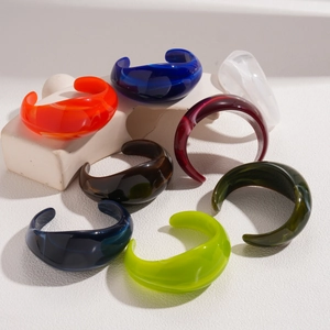 Detail shot of chunky colorful acrylic open bangles in various marbled resin shades