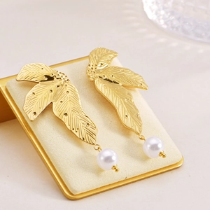 Irregular silver leaf earrings with pearl drop on a velvet display stand