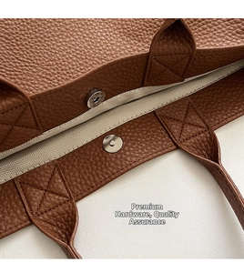 Detail des Magnetverschlusses und der X-Nähte an der braunen Leder-Tote-Bag aus Litschi