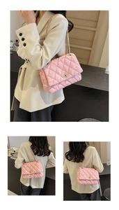 Detailed view of pink quilted leather shoulder bag with golden petal clasp and chain strap