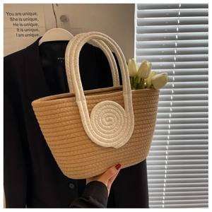Detail of hand-woven cotton rope tote with circular pattern and braided handles