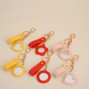 Close-up of heart and flower leather mirror keychains in yellow, red, and pink colors