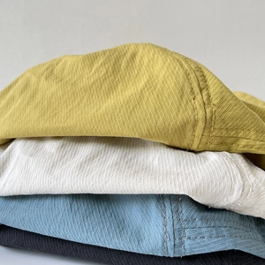Stack of quick-dry nylon bucket hats in yellow, beige, blue, and black colors