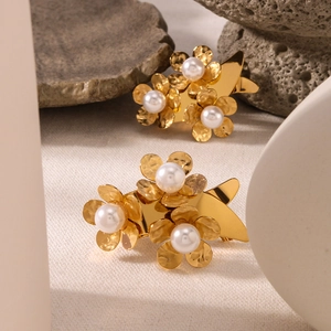 Polished gold floral drop earrings featuring centered pearls on a natural stone base
